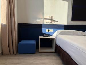 a bedroom with a bed and a blue wall at Amura Alcobendas in Alcobendas