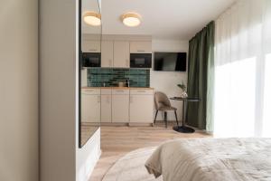 a bedroom with a bed and a kitchen at BLI One in Vilsbiburg