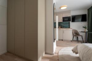 a bedroom with a bed and a kitchen at BLI One in Vilsbiburg