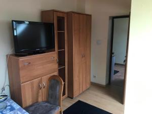 a living room with a television on a wooden cabinet at Noclegi Ściegiennego in Sosnowiec