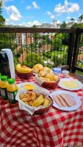 a picnic table with baskets of food on a checkered table cloth at Le Ville - Campos do Jordão in Campos do Jordão
