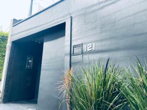 a gray building with a door and some plants at Studiohaus Pertence in São Paulo