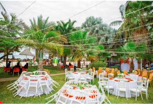 a group of white tables and chairs in a field at Kijiji Beach Resort in Dar es Salaam +97 photos