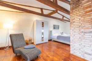 a bedroom with a bed and a chair and a brick wall at Lodge an der Muehle in Bredstedt