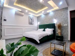 a bedroom with a bed with a green headboard at Résidence Luxury in Abidjan