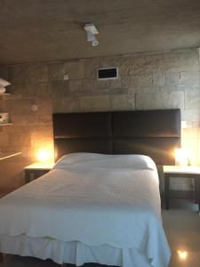 1 dormitorio con 1 cama grande y 2 mesas con luces en Apartment in Linda Bay Complex en Mar de las Pampas
