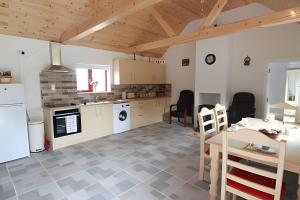 a kitchen and dining room with a table and chairs at Historic Louisburgh Farm Cottage in Louisburgh