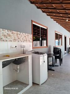 a kitchen with a counter and a sink and a table at Casa em Prado bahia in Prado
