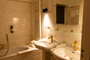 a bathroom with a sink and a tub and a toilet and a mirror at Hotel Schimmelpenninck Huys in Groningen