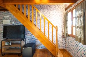a wooden staircase with a television in a room at Palacio de Arce in Puente Arce