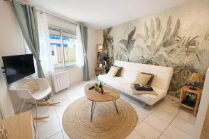 a living room with a couch and a table at La Perle de la Baie - Plages à pied & Hyper centre in Pornichet