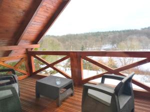 a porch with chairs and a table on a deck at Gajówka Świt in Łyskowo