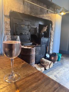 a glass of wine sitting on a table in front of an oven at Sheepfold lodge in Sedbergh