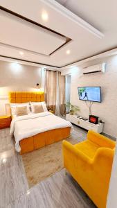 a bedroom with a large bed and a flat screen tv at Résidence Luxury in Abidjan