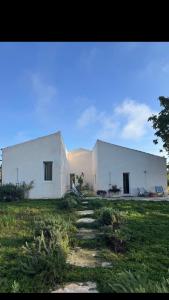 a large white building in a field of grass at Aguglia Persa - Double Room in Noto