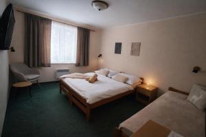 a hotel room with two beds and a stuffed animal on the bed at Horský Hotel Magura in Chvojnica +46 photos