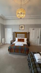 a bedroom with a large bed and a chandelier at Kingston Guesthouse in Edinburgh
