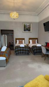 a hotel room with two beds and a chandelier at Kingston Guesthouse in Edinburgh