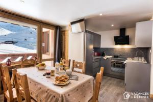 a kitchen and dining room with a table with food on it at D2 Luxury Chalet Mountain View Sleeps 12 Coffee in Val Thorens