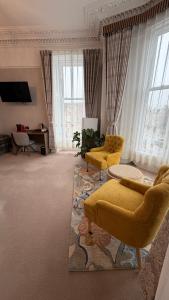 a living room with two yellow chairs and a couch at Kingston Guesthouse in Edinburgh +50 photos