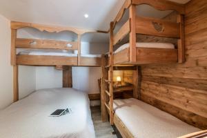 two bunk beds in a room with wooden walls at D2 Luxury Chalet Mountain View Sleeps 12 Coffee in Val Thorens
