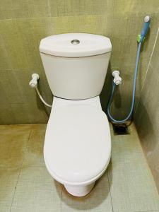 a white toilet in a bathroom with a shower at Ranathunga Guest Kataragama in Kataragama