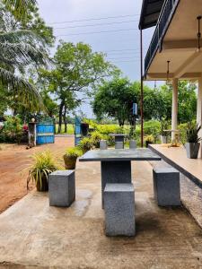 a picnic table with two benches in a park at Ranathunga Guest Kataragama in Kataragama