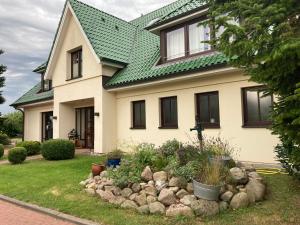 a house with a green roof and a rock garden at Flair-Hotel Neeth in Lehmkuhlen