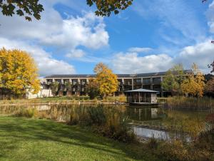 an university building with a pond in front of it at Ströbinger Hof - Therme Wellness Resort in Bad Endorf