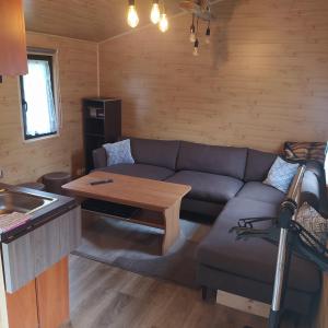 a living room with a couch and a table at Domki nad Wałpuszem in Stare Kiejkuty