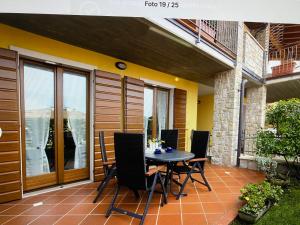 a patio with a table and chairs on a balcony at Residenz Fontana mit Pool in San Zeno di Montagna
