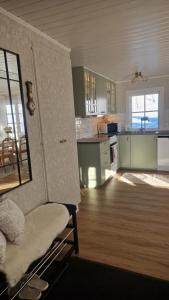 a kitchen with green cabinets and a chair in a room at Säbytorp in Kil