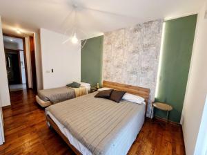 two beds in a room with green walls and wooden floors at hotel al palazat in Cavasso Nuovo