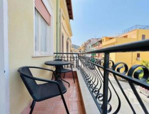 a balcony with chairs and a table on a building at Casa Kennedy in Capaci