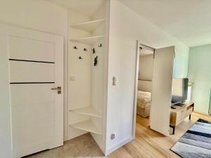 a white room with a closet and a bed at Jarzebinowa Loft by JumpInHere in Nowy Dwór Mazowiecki