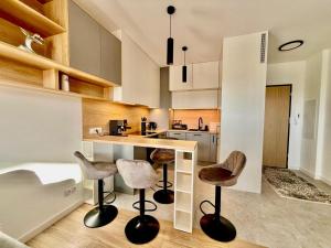 a kitchen with a counter and stools in it at Jarzebinowa Loft by JumpInHere in Nowy Dwór Mazowiecki