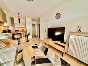 a living room with a flat screen tv and a couch at Jarzebinowa Loft by JumpInHere in Nowy Dwór Mazowiecki