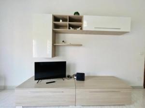 a tv sitting on top of a wooden stand in a room at Casa Kennedy in Capaci +7 photos