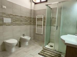 a bathroom with a toilet and a sink and a shower at Casa Kennedy in Capaci