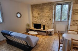 a living room with a couch and a tv at Ma Location Saisonnière in Chasseneuil-du-Poitou