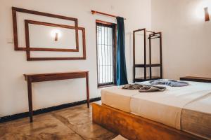 a bedroom with a bed with a table and a mirror at Secret House in Dickwella