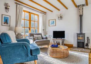 a living room with a blue couch and a tv at Charming Family Stables Conversion - Pass the Keys in Emsworth