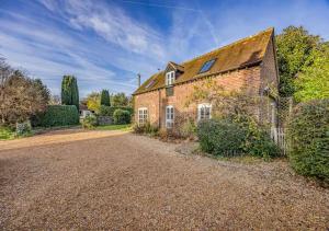 an old brick house with a gravel driveway at Charming Family Stables Conversion - Pass the Keys in Emsworth
