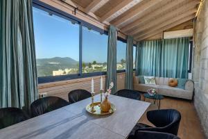 a room with a table and chairs and a large window at Even Vanof - אבן ונוף in Safed