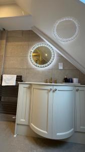 a bathroom with white cabinets and a mirror at Kingston Guesthouse in Edinburgh