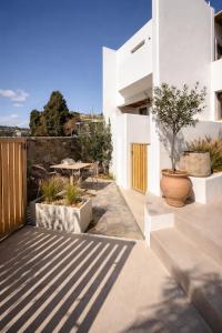 a patio with a table and some potted plants at REYA suites in Aliki