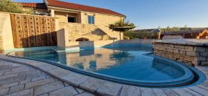 a swimming pool in front of a house at Villa Stone Lace in Kolan