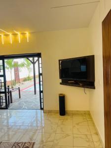 a living room with a flat screen tv on the wall at Casa Yangu in Watamu