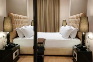 ein Schlafzimmer mit einem Bett, zwei Lampen und einem Spiegel in der Unterkunft Hotel Luxury in Ksamil