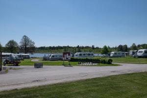 a parking lot with a bunch of rvs parked next to a lake at Djulöcamping in Katrineholm +1 photo